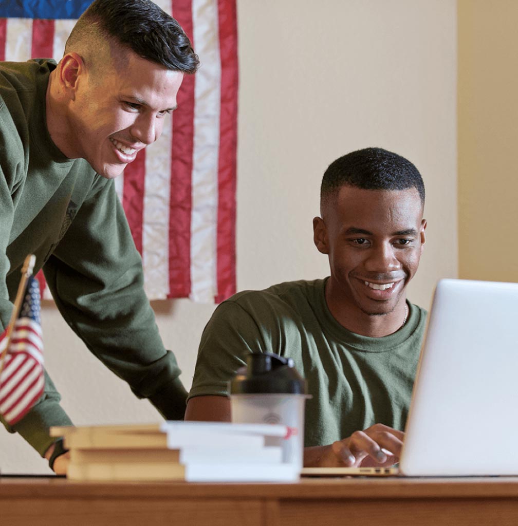 Service members looking at a laptop